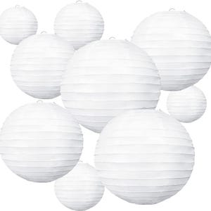 May include: A collection of white paper lanterns in various sizes. The lanterns are round with horizontal pleats, and each has a small metal hook at the top for hanging. The lanterns are arranged against a white background.