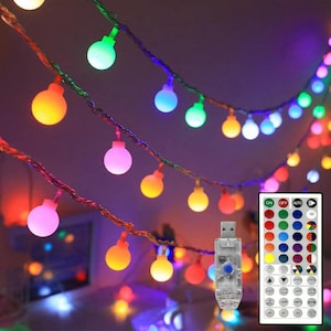 May include: A string of multi-colored LED globe lights with a thin copper wire, featuring a USB connector and a remote control with various color, brightness, and mode settings including fade, jump, and strobe options for customizable lighting.