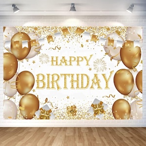 May include: A white backdrop with gold text that reads "HAPPY BIRTHDAY". The backdrop is decorated with gold balloons, confetti, and gift boxes. White and gold pennant banners are strung across the top. The overall theme is a birthday celebration.