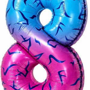 May include: A foil balloon shaped like the number eight, featuring a vibrant blue top section and a bright pink bottom section, both decorated with a repeating pattern of dark blue flame-like or abstract curved shapes across the surface.