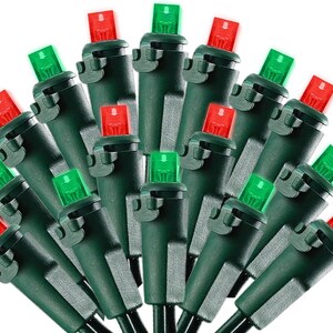 May include: A string of LED holiday lights featuring alternating red and green bulbs. Each bulb is encased in a dark green plastic housing with a small clip attached to the side, connected by a dark green wire arranged in a fan-like pattern.
