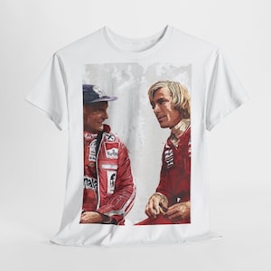 Könnte beinhalten: Weißes T-Shirt mit einem Aquarell-Porträt von zwei Formel-1-Rennfahrern in roten Rennanzügen. Einer trägt eine blaue Kappe. Das Bild hat eine Vintage-Ästhetik mit verblasstem Hintergrund.