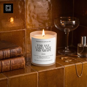 May include: A frosted glass candle with a lit wick and a white label reading 1001MOCKUPS & CO. FOR ANY LABEL SIZE AND SHAPE 250G. The label includes text about non-toxic soy wax, essential oils, and coffee beans. The candle sits on a brown tiled surface.