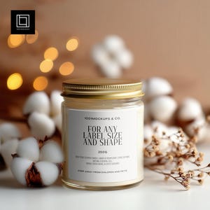 May include: A clear glass jar candle with a gold lid and a white label. The label reads "FOR ANY LABEL SIZE AND SHAPE" and "250g". The candle is surrounded by cotton bolls and dried flowers, with soft bokeh lights in the background.