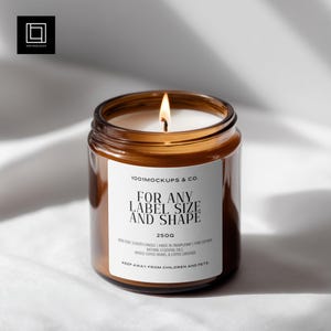 May include: A lit, amber-colored glass jar candle with a white label. The label reads "FOR ANY LABEL SIZE AND SHAPE" and "250g". The candle is on a white surface. The candle is a non-toxic scented candle.