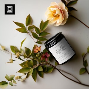 May include: A black jar with a black lid and a white label that reads "FOR ANY LABEL SIZE AND SHAPE". The jar is surrounded by green leaves, small orange and red flowers, and a peach-colored flower. The jar is 250g.
