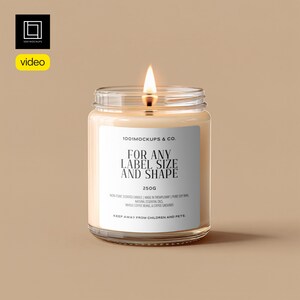 Pode incluir: Uma vela acesa num frasco de vidro transparente com uma etiqueta branca. A etiqueta diz "FOR ANY LABEL SIZE AND SHAPE" e "250g". A vela está rotulada "1001MOCKUPS & CO." e "KEEP AWAY FROM CHILDREN AND PETS".