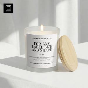 以下が含まれることがあります： 木製の蓋が付いた、火の灯ったすりガラスのキャンドル。キャンドルには「1001MOCKUPS & CO.」と「FOR ANY LABEL SIZE AND SHAPE」の文字が入った白いラベルが付いています。重さは250gです。キャンドルは白い表面に置かれています。