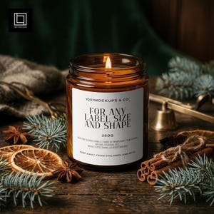 May include: A lit scented candle in an amber glass jar with a white label reading 1001MOCKUPS & CO. FOR ANY LABEL SIZE AND SHAPE 250G. The candle is surrounded by dried orange slices, star anise, cinnamon sticks, and evergreen pine needles.