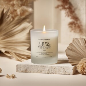 May include: A lit, frosted glass candle with the text "FOR ANY LABEL SIZE AND SHAPE" is centered on a stone block. Dried plants and decorative elements surround the candle, creating a neutral, earthy aesthetic. The candle is labeled "150g".
