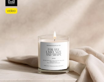 May include: A burning scented candle in a clear glass jar. The candle has a white label with the text "FOR ANY LABEL SIZE AND SHAPE" and "250G". The candle is on a white surface with a beige cloth.