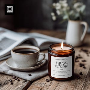 May include: A lit candle in a brown glass jar with a white label that reads "FOR ANY LABEL SIZE AND SHAPE" sits on a wooden table. A cup of coffee and a saucer are to the left, with coffee beans scattered around.