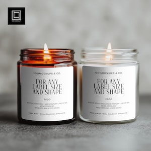 May include: Two glass jar candles with lit wicks. One candle has a brown glass jar, the other is clear. Each candle has a white label with black text that reads "FOR ANY LABEL SIZE AND SHAPE" and "250g".