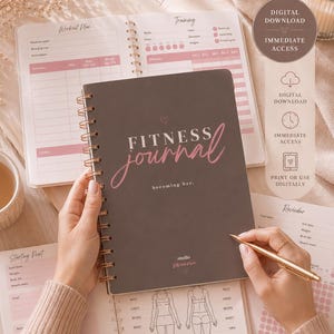 Op de afbeelding: Een donkergrijs fitnessdagboek met spiraalbinding en de tekst Fitness journal becoming her. Het dagboek bevat interne pagina's met trainingsschema's, logboeken en diagrammen voor lichaamsmaten. Een gouden pen ligt op de open pagina's.