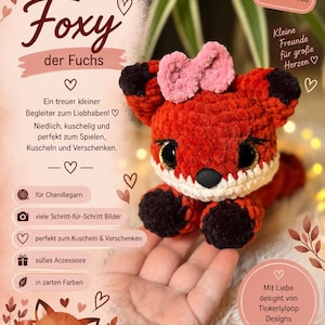 Könnte beinhalten: Ein gehäkeltes Fuchskuscheltier aus orangefarbenem und weißem Garn mit schwarzen Ohren und Pfoten sowie einer rosa Schleife auf dem Kopf. Das Bild enthält den Text: Foxy der Fuchs, PDF Anleitung zum Download, Kleine Freunde für große Herzen, Mit Liebe designt von Tinkerlyloop Designs und Schwierigkeitsgrad: Einfach.