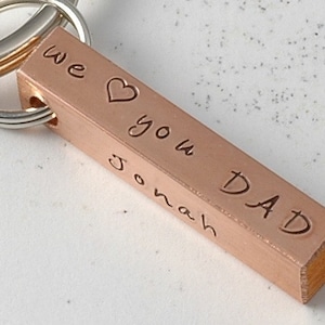May include: A copper bar keychain with the words "we love you Dad" and the name "Jonah" engraved on it.