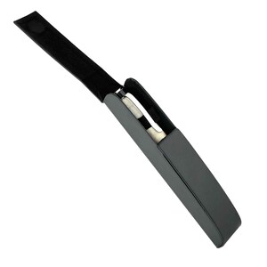 May include: A black, rectangular case with a matching strap and a silver object inside. The case is open, revealing the contents. The strap has a velcro closure.