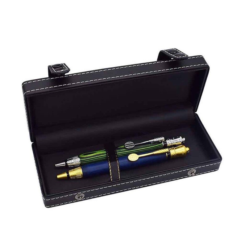 May include: Black leather pen case with white stitching, holding three pens. The pens are green, blue, and silver with gold accents. The case has a clasp closure and a strap to secure the pens.