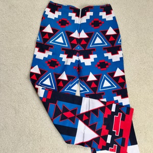 May include: Blue, red, white, and black patterned pants with a geometric design.