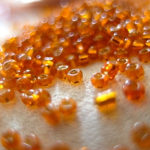 100 grams Pumpkin Orange silver-lined Rocaille seed beads, approx. 10,000 beads per bag. size 10/0