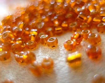 100 grams Pumpkin Orange silver-lined Rocaille seed beads, approx. 10,000 beads per bag. size 10/0