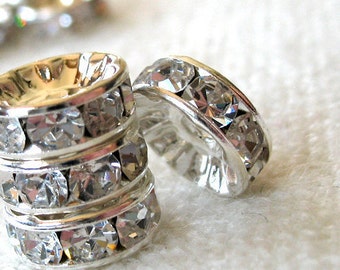 May include: Silver-toned ring with multiple rows of clear rhinestones. The ring is a decorative piece for jewelry making.