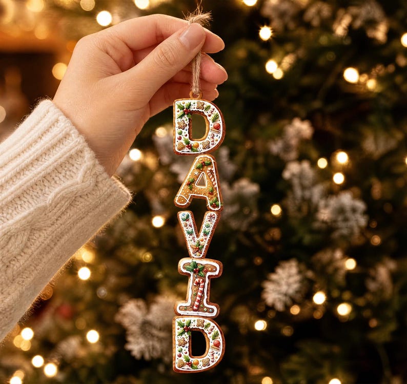 May include: A vertical hanging ornament spelling the name DAVID, crafted to resemble gingerbread cookies with white icing details, holly leaves, berries, and candy canes. Each letter is connected by small rings and suspended by a rustic twine loop.