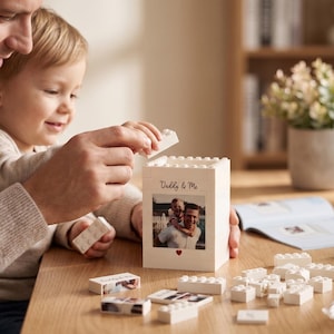 May include: A white Lego-style block container with a photo and the text "Daddy & Me". The container is being assembled with white Lego bricks. A photo of a father and child is on the front, with a small red heart below.