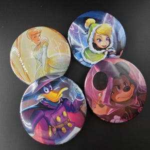 May include: Four round, colorful character buttons featuring Cinderella in a yellow gown, Tinkerbell in a green cloak, Darkwing Duck in a purple outfit, and Mickey Mouse in a purple cloak. The buttons are glossy and have a cartoon style.