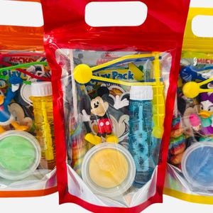 May include: Three clear plastic bags with colorful contents. Each bag features a different Disney character, including Mickey Mouse and Donald Duck. The bags contain toys, bubbles, and play dough. The bags are orange, red, and yellow.