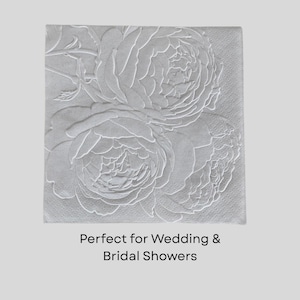 Puede incluir: Servilleta de papel cuadrada gris claro con un dise&ntilde;o floral en relieve con tres grandes flores de peon&iacute;a. El texto "Perfect for Wedding & Bridal Showers" est&aacute; impreso en la parte inferior de la servilleta.