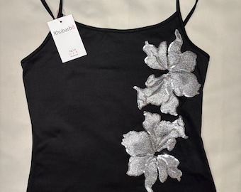 May include: Black camisole top with silver floral embellishments. The top features thin straps and a tag that reads "Rhubarb". A stylish and elegant piece for any wardrobe.