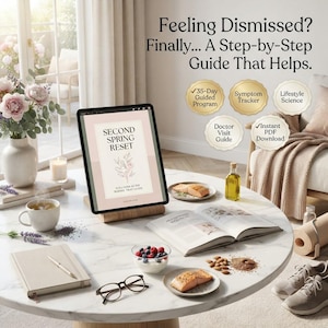 May include: A tablet on a wooden stand displays a digital guide titled Second Spring Reset. The screen shows text and a floral illustration. Surrounding items include a bowl of berries, salmon fillets, a notebook, glasses, and wellness badges.