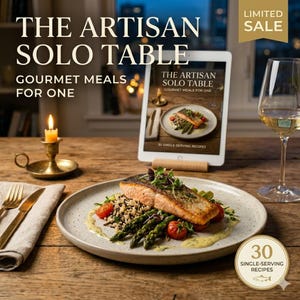 Puede incluir: Una comida gourmet para uno se presenta en un plato moteado, con salmón, espárragos y tomates. Una tableta muestra el libro "The Artisan Solo Table" con 30 recetas individuales. Una vela encendida y una copa de vino completan la escena.