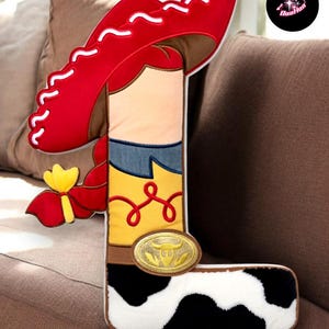 A large letter "L" made of fabric, resembling a cowboy boot, is displayed on a couch.
