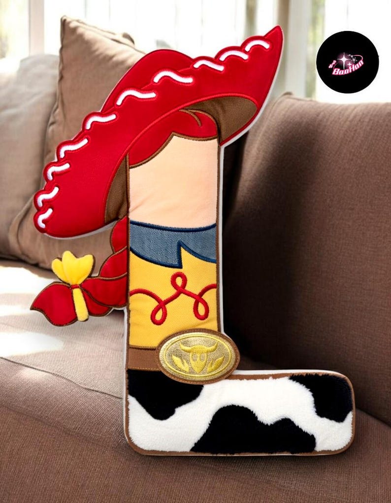 A large letter "L" made of fabric, resembling a cowboy boot, is displayed on a couch.