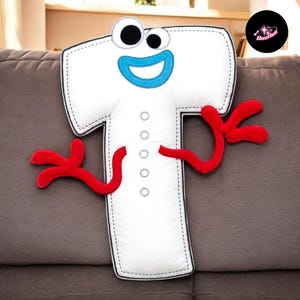 A plush toy of the character "T" from the animated film "Frozen" is sitting on a couch.