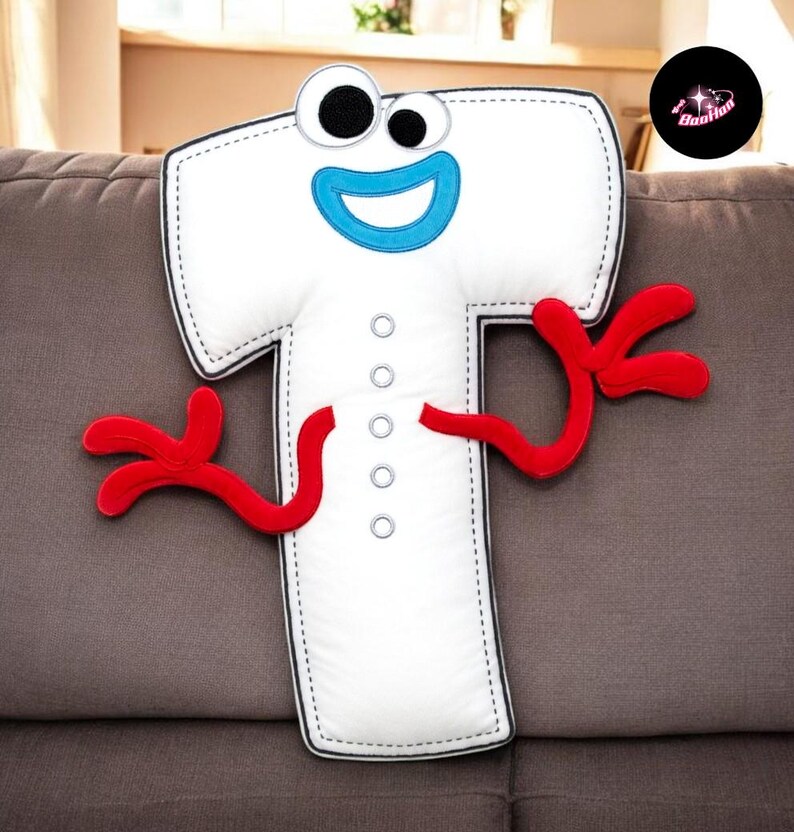 A plush toy of the character "T" from the animated film "Frozen" is sitting on a couch.