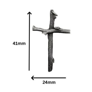 May include: A rustic-style cross pendant, 41mm in height and 24mm wide, crafted from a dark, textured material. The cross features a loop at the top for hanging and is designed to resemble a natural branch.