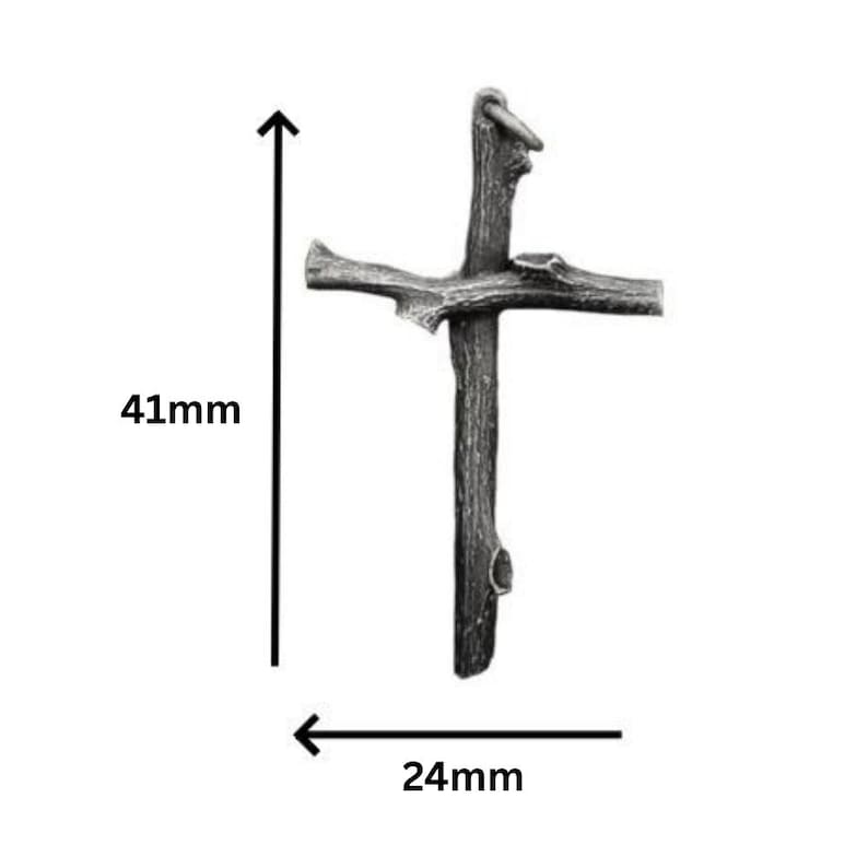 May include: A rustic-style cross pendant, 41mm in height and 24mm wide, crafted from a dark, textured material. The cross features a loop at the top for hanging and is designed to resemble a natural branch.