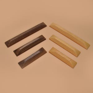 May include: Six wooden keyboard keycaps in two colors: three dark brown and three light brown. The keycaps are rectangular with beveled edges and a slightly concave top surface. The keycaps are arranged on a neutral background.