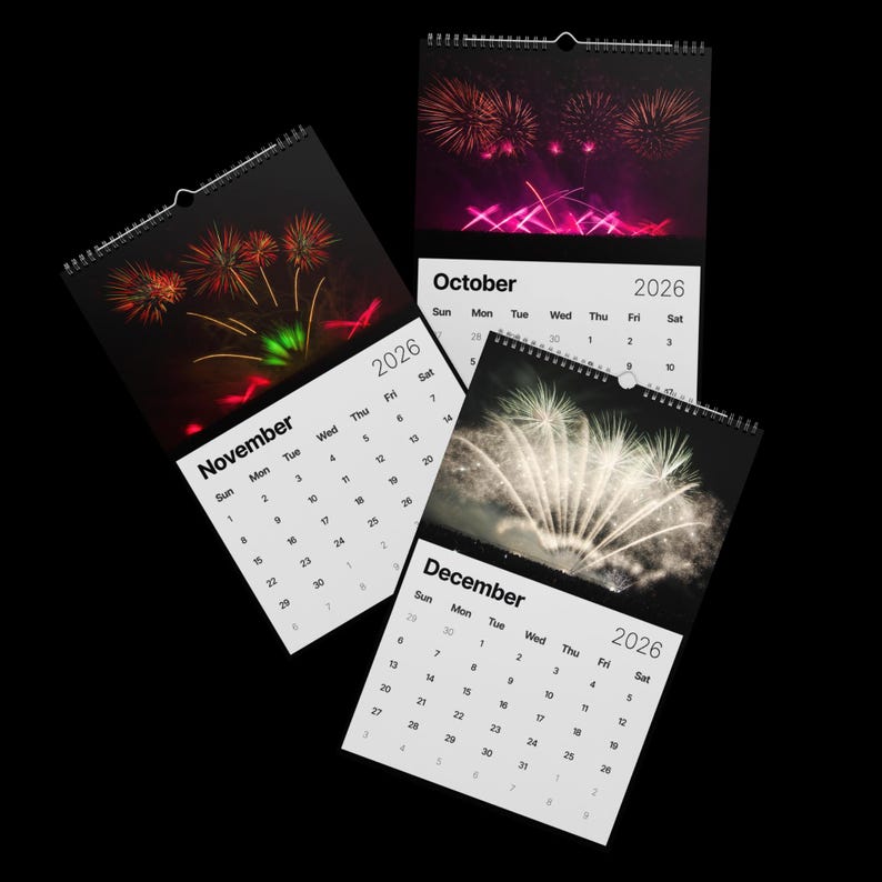 May include: Three spiral-bound 2026 calendars with fireworks images for October, November, and December. Each calendar has a white background with the month and year printed in black.