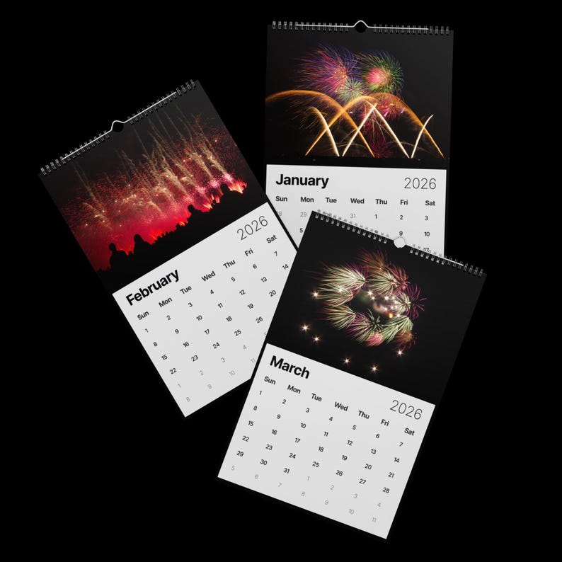 May include: Three spiral-bound 2026 calendars with images of fireworks against a black background. The calendars are open to January, February, and March. Each calendar page displays the month and year, with a grid of dates.
