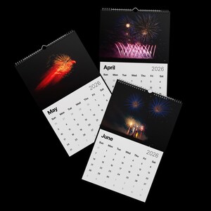 May include: 2026 wall calendars featuring vibrant fireworks displays. Each calendar shows a different month: May, April, and June. The calendars have a black background and a spiral binding at the top.