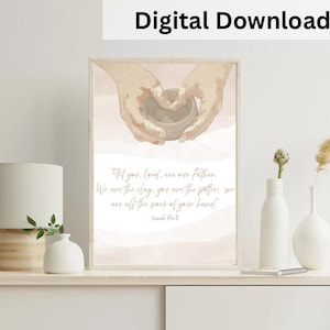May include: A framed digital download print featuring hands shaping a clay pot. The artwork has a watercolor style with soft pink and beige tones. Text reads "Yet you, Lord, are our father. We are the clay, you are the potter, we are all the work of your hand."