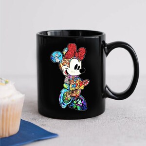 Puede incluir: Taza de cer&aacute;mica negra con un dise&ntilde;o colorido de Minnie Mouse. Minnie se representa caminando, con un lazo rojo y un collage de personajes de Disney. La taza tiene un asa grande y es adecuada para bebidas fr&iacute;as o calientes.