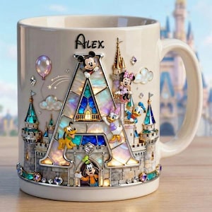 May include: Cream-colored ceramic mug featuring a castle design with Disney characters. The letter "A" is the focal point, with Mickey Mouse, Minnie Mouse, Donald Duck, Daisy Duck, Pluto, and Goofy. The name "Alex" is written on the top.