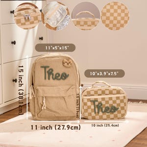 Op de afbeelding: Beige corduroy rugzak, 27,9 cm x 12,7 cm x 38,1 cm, met de naam "Theo" in groen schrift en een kattenkop patch. Een bijpassende lunchtas, 25,4 cm x 9,9 cm x 19 cm, heeft een ruitpatroon en de naam "Theo".
