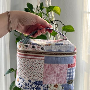 May include: A white ceramic mug with a black handle and the text "But First, Coffee" in a bold, black font. The mug is sitting on a wooden surface.