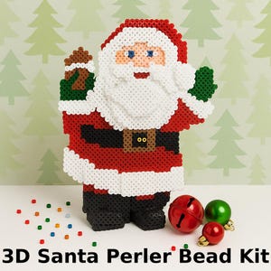 Puede incluir: Un kit de cuentas Perler 3D con una figura de Papá Noel en rojo, blanco, negro y marrón. La figura tiene barba blanca y gorro rojo. La imagen también incluye adornos navideños rojos, verdes y dorados. El texto en la parte inferior dice "3D Santa Perler Bead Kit."